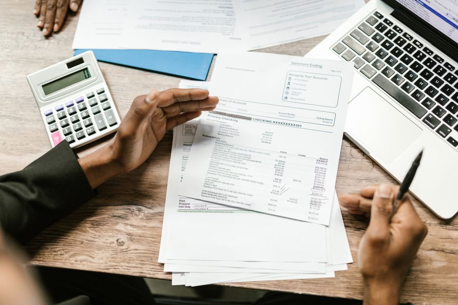 A homeowner reviewing remodeling documents spread out on a kitchen counter.