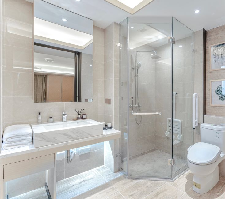 A compact bathroom with a walk-in shower, streamlined vanity, and open floor area.