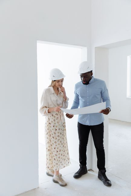 A homeowner and design professional reviewing blueprints and site plans for a backyard ADU project.