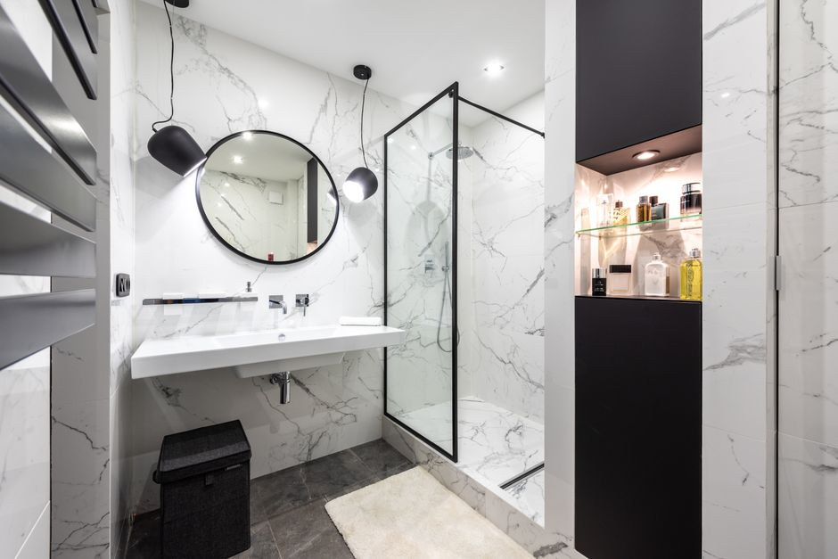 A modern walk-in shower with frameless glass, built-in niche storage, and clean tile detailing.