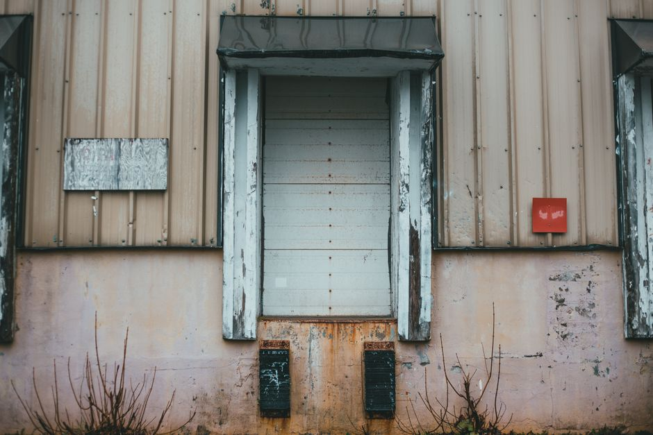 A warehouse loading dock with dock doors, seals, and trailer access points visible along the building edge.