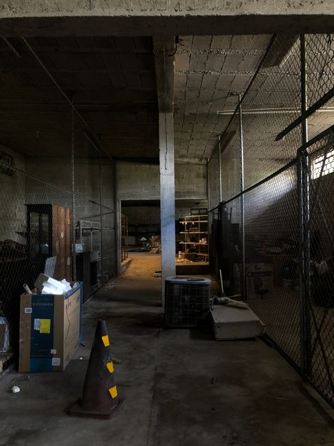 Rows of palletized goods staged in a warehouse with narrow visibility lines near walls and floor space.