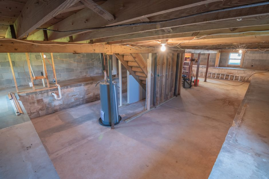 A residential garage mid-conversion with framing and renovation materials visible.