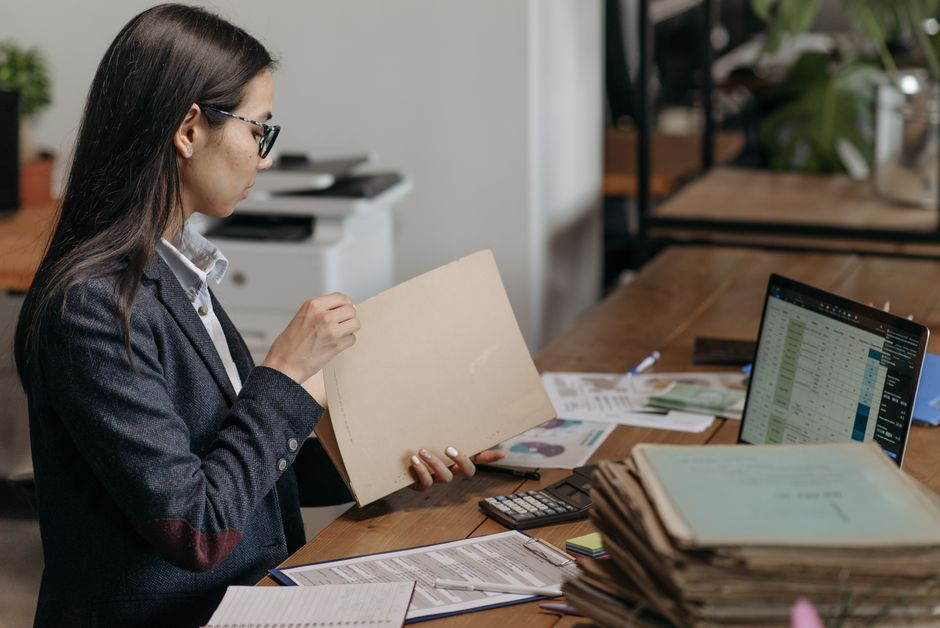 A small business owner at a desk reviewing insurance paperwork and a contract.
