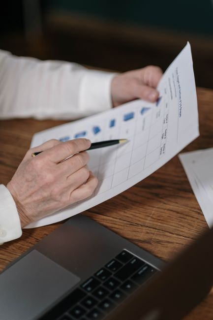 A car shopper reviewing paperwork with financing figures at a dealership desk.