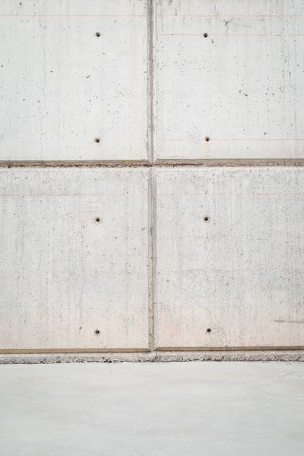 Close view of a home's exterior foundation line and wall transition being inspected for small gaps.