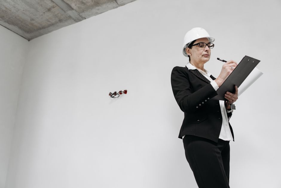 A homeowner and roofing contractor reviewing a roof estimate and inspection notes outside a house.