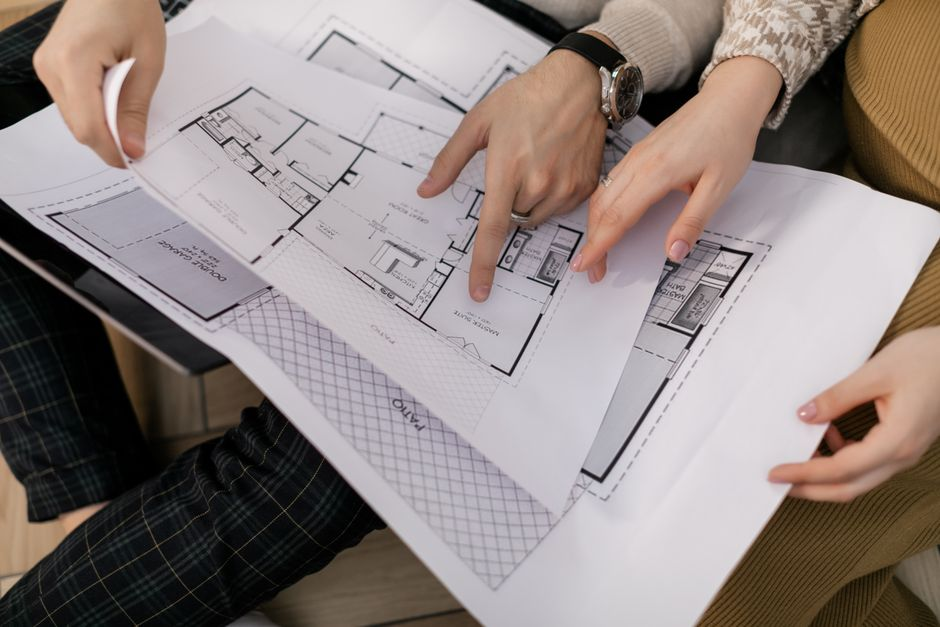 Architectural plans and sketches spread across a table for a residential remodel project.