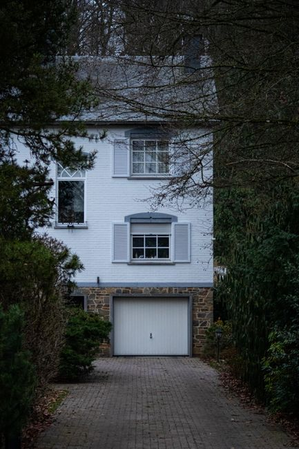 A suburban property showing a main house with a backyard accessory structure and converted garage-style living space.