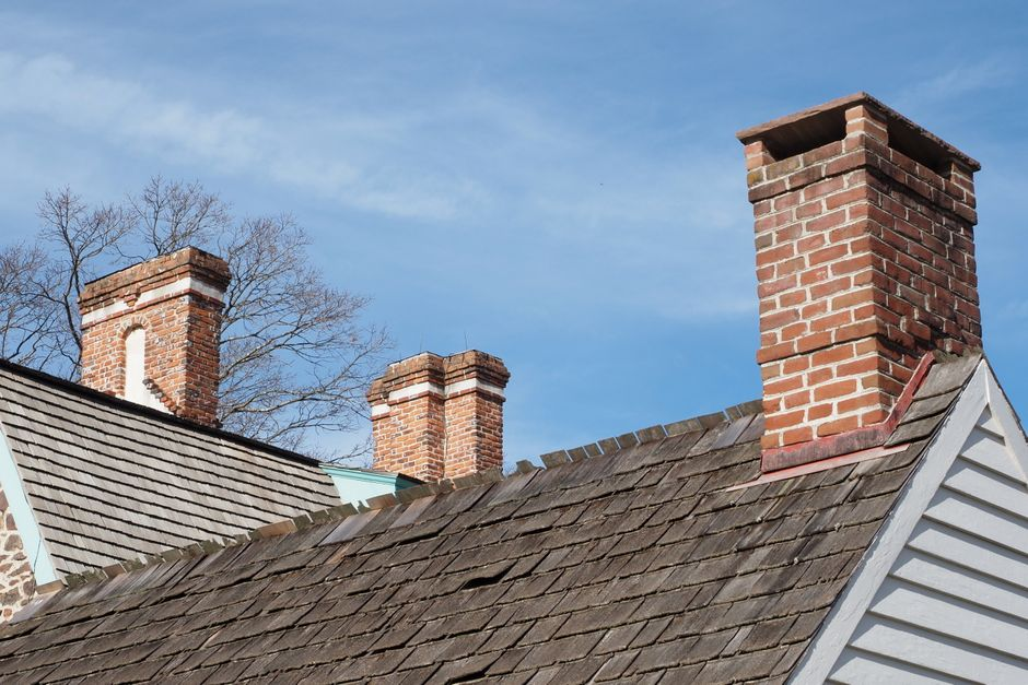A residential home with a clearly visible pitched roof in direct sunlight.