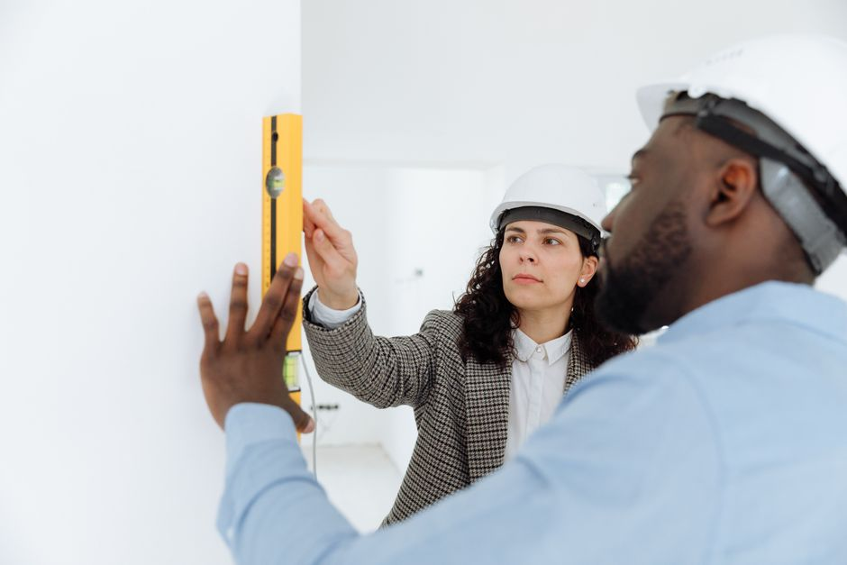 Restoration technician using a moisture meter to check a wall for lingering dampness.