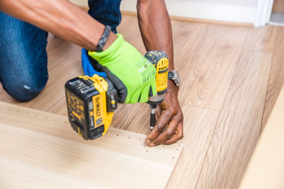 Contractor inspecting damage to a finished wood floor in a home.