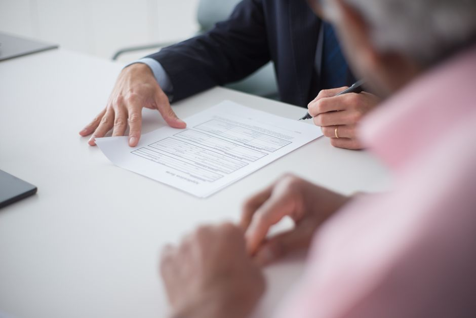 Service provider reviewing an agreement and work details at a desk before a client assignment.