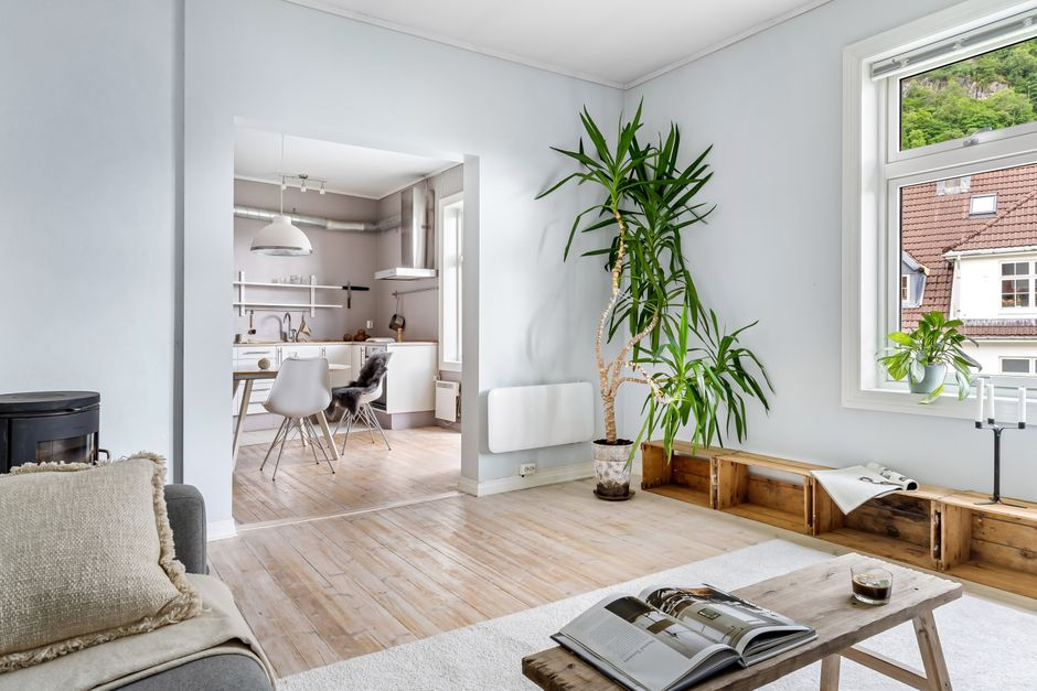 Daylight entering a living room through windows beside an opening to another room, illustrating light flow between old and new spaces