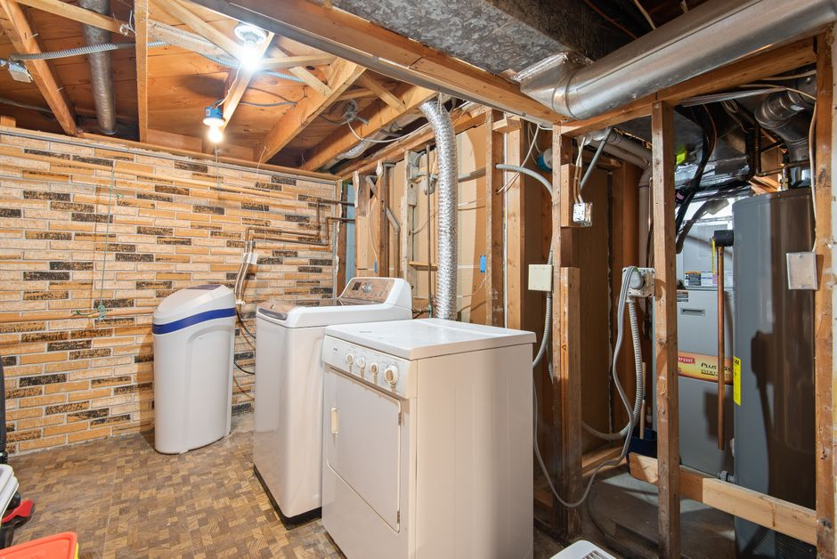 Exposed wall studs and plumbing in a kitchen under renovation.