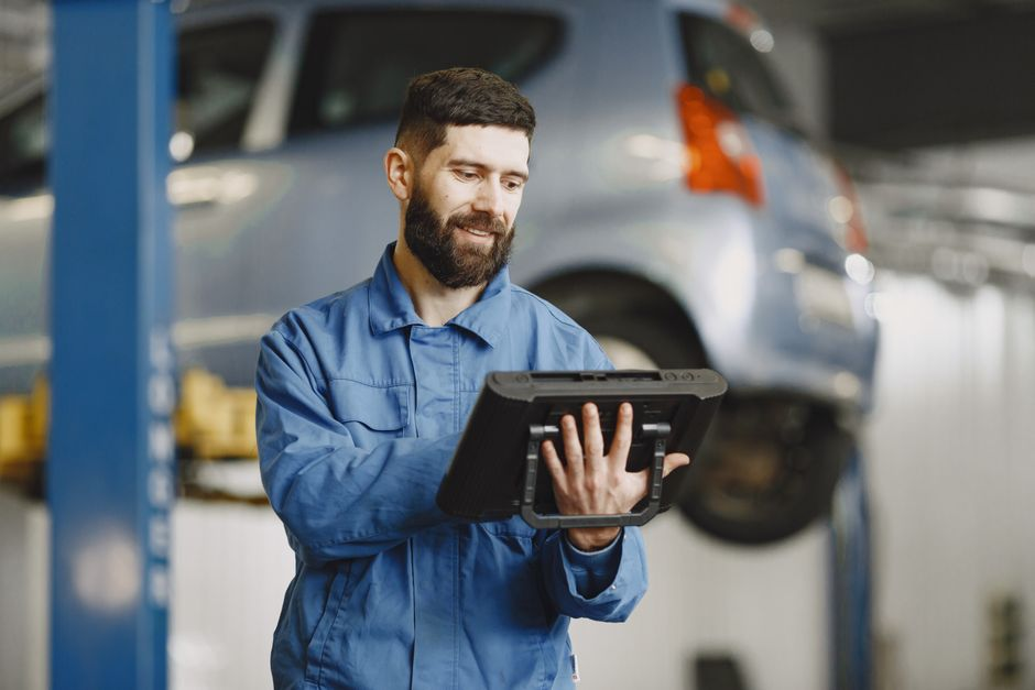 Mechanic inspecting a car in a workshop.