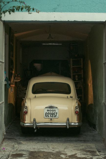 Storage shelves and a parked car inside a residential garage.