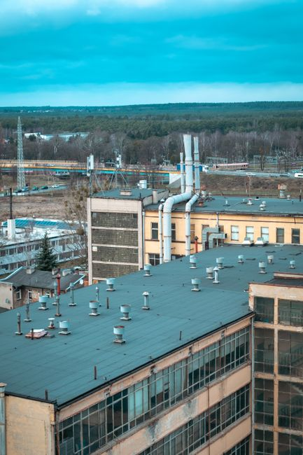 Overhead view of industrial piping and utilities above a factory production area.
