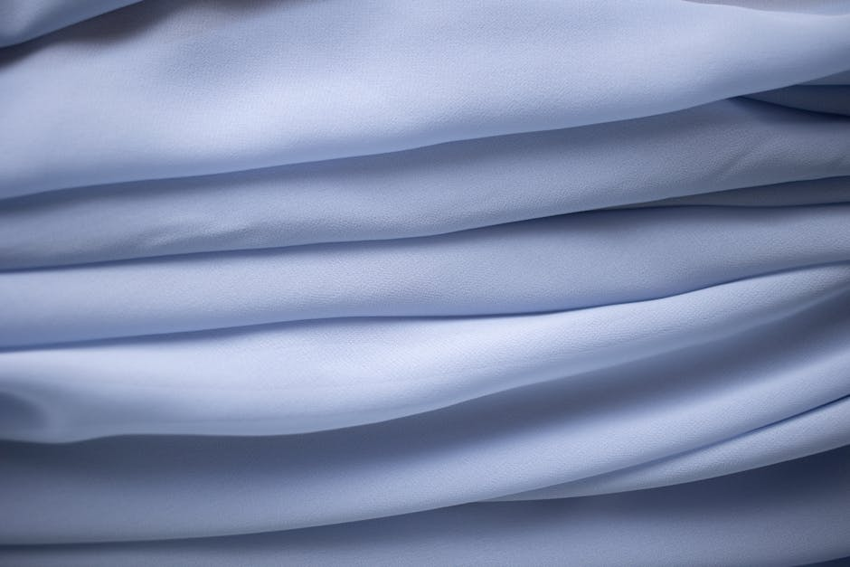 Soft fabric draped in long folds for an event or backdrop setup, showing width and fullness.