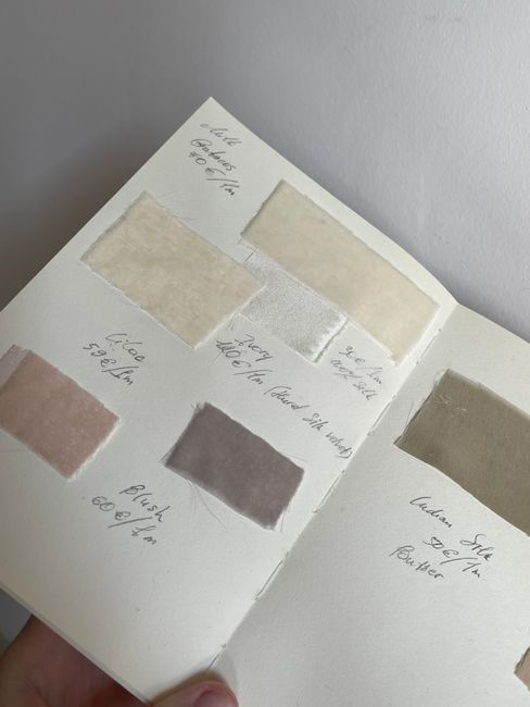 Close-up of several fabric swatches in matte, sheer, and satin finishes laid side by side for comparison.