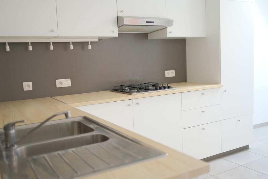Smoke-stained kitchen walls and upper cabinets with visible soot residue beyond the main burn area.