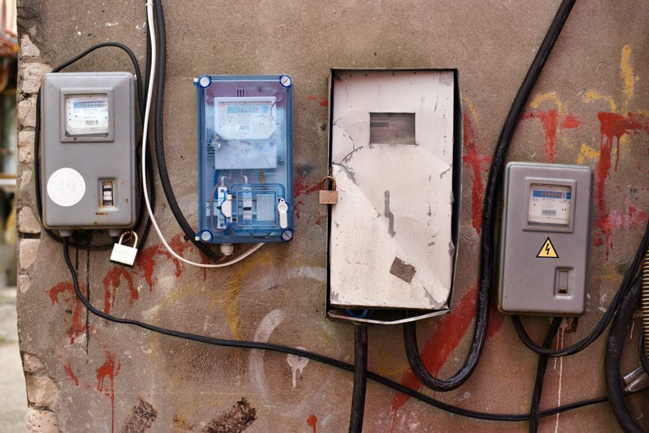 Close-up of industrial conduit or cable entry points along a utility or control-building wall.