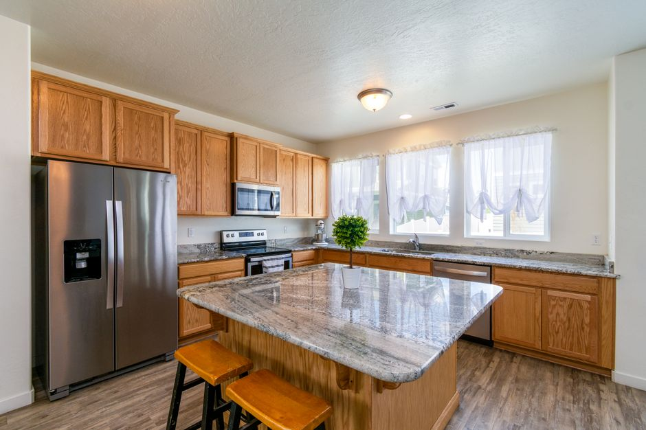 A kitchen where an island and surrounding cabinets create a tight walkway for people moving past each other.