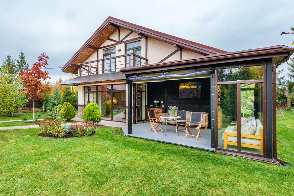 A multigenerational family standing between a main house and a separate backyard living unit.