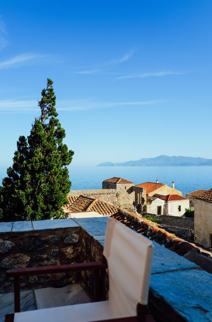 A private hotel terrace with chairs and an open sea view, set up for a quiet morning coffee.