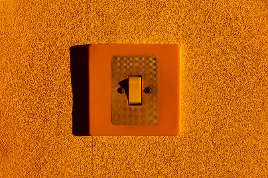 Close-up of a residential wall outlet and switch plate in an older home interior.