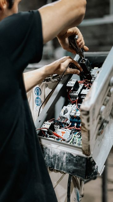 Open residential circuit breaker panel being inspected by an electrician.