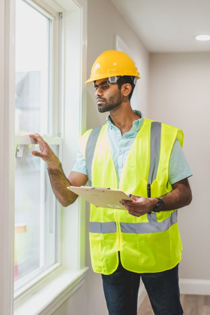 A roofing professional inspecting a residential roof and documenting conditions.