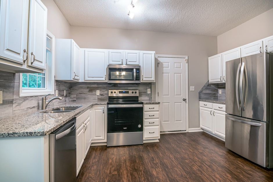 Partially finished kitchen with cabinets being installed and exposed wall areas still visible above the countertop.
