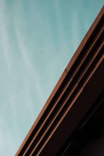 Close-up of commercial roof flashing, drain area, and edge metal detail on a flat roof.
