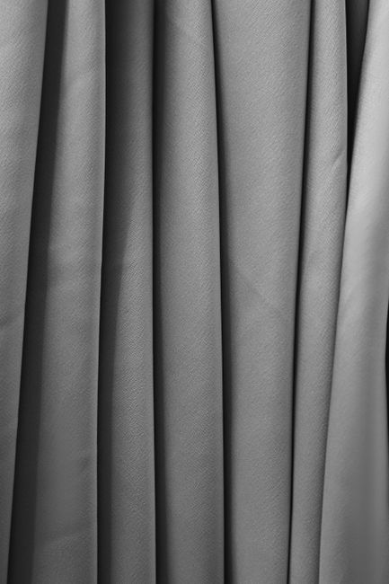 A close-up of multiple fabric swatches with different weights and textures draped side by side.