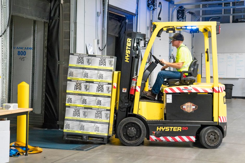 An industrial warehouse loading dock with dock doors, pallets, and staging areas visible during an inspection.