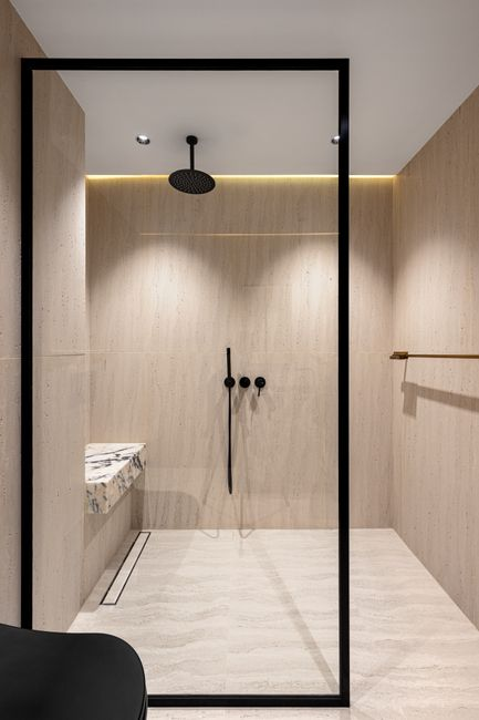 A bright modern bathroom with a large window and glass shower enclosure designed for privacy and daylight.