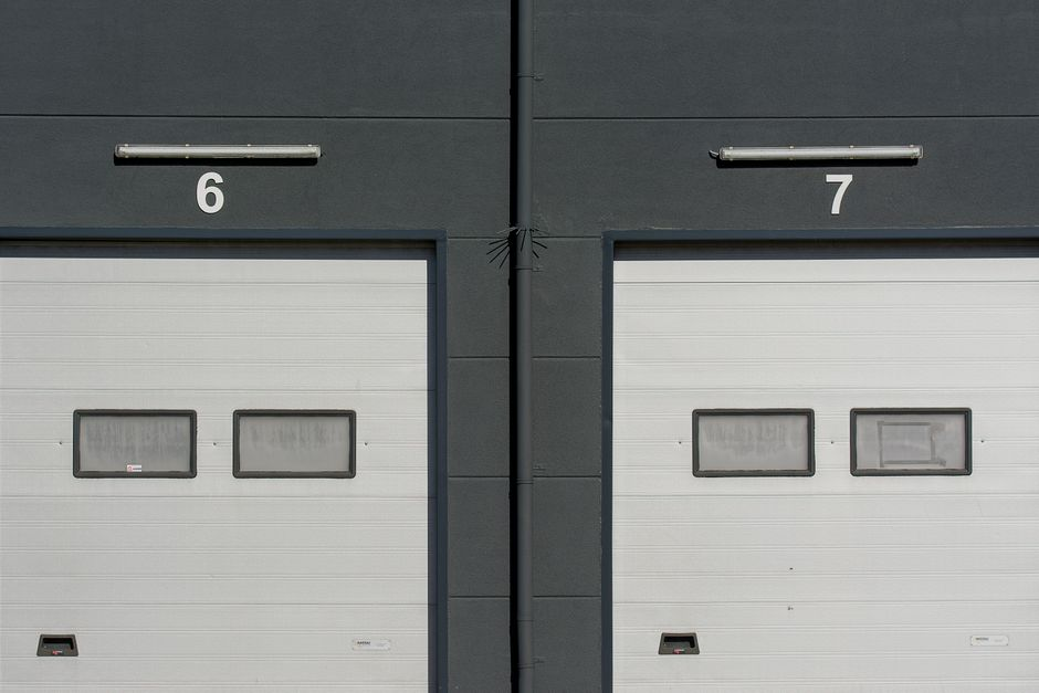 A maintenance or inspection professional walking through a large commercial or warehouse interior during a facility check.