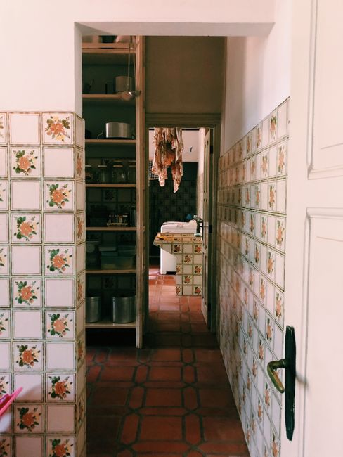 A kitchen or pantry baseboard area showing small debris and a narrow gap near cabinets.