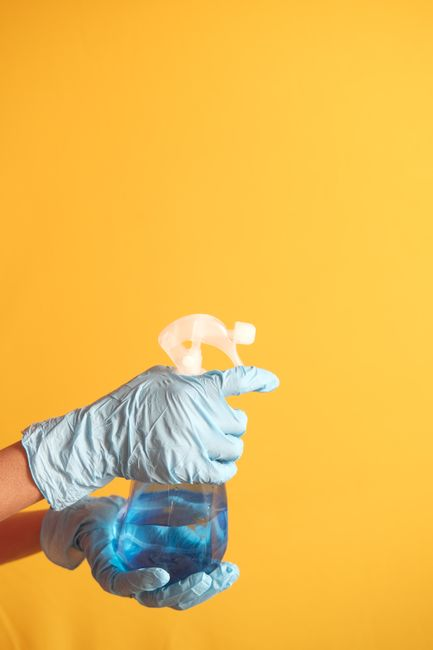 A worker in protective gear performing careful cleaning in an industrial facility.