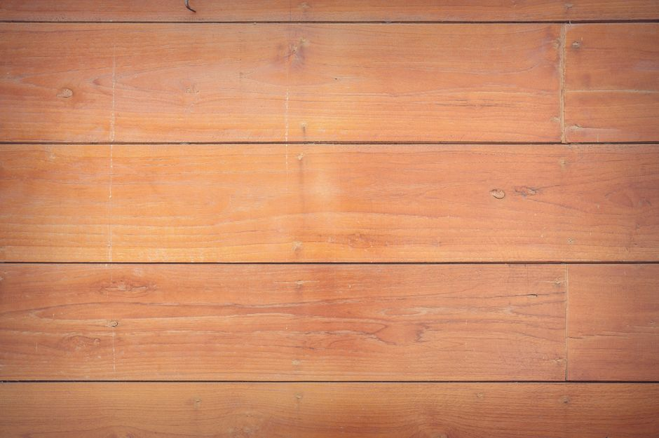A hardwood floor being sanded and refinished in a room with good ventilation.