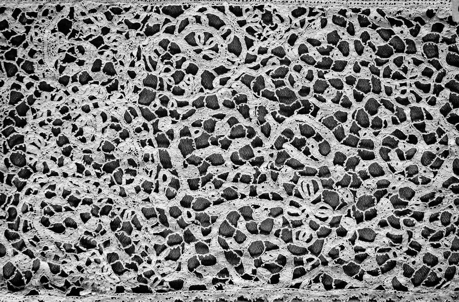 Close-up of brocade fabric showing an ornate woven pattern with visible texture and structure.