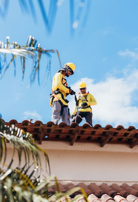 A roofing professional inspecting a residential roof and evaluating its condition.