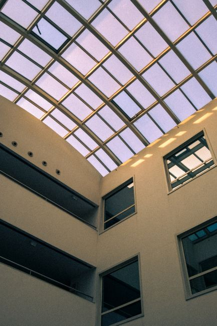 Interior commercial space with a ceiling water stain and a bucket catching roof leakage.