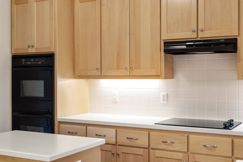 A clean modern kitchen with updated cabinets, counters, backsplash, and fixtures but an otherwise standard layout.