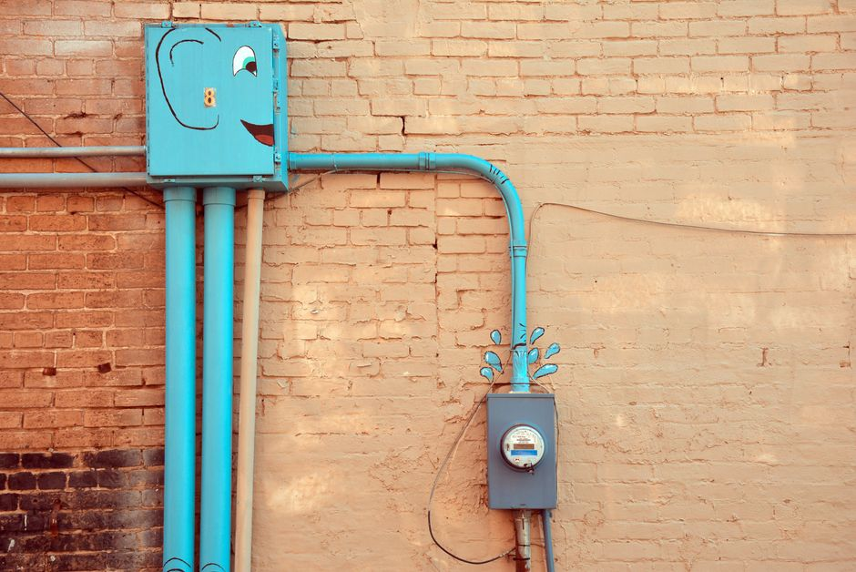Utility pipes and cables entering an exterior wall with sealed gaps around the penetrations.