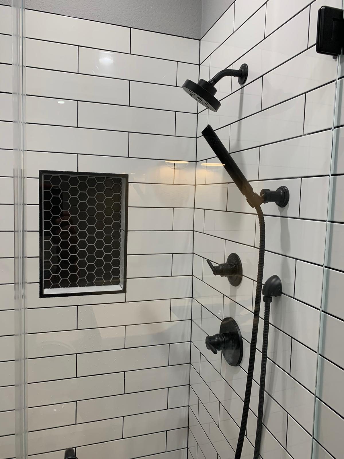 Shower, black fixtures, tile wall